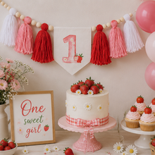 Load image into Gallery viewer, A styled first birthday party setup with a strawberry-topped cake on a pink cake stand, pink cupcakes, a sign reading 'One sweet girl,' flowers in a white vase, and a tassel banner with a number 1 flag. Balloons are visible on the right, and the scene is photographed indoors against a light neutral wall.
